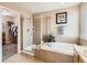 Bright bathroom with shower, soaking tub, and a door to walk-in closet at 8522 S Dudley St, Littleton, CO 80128