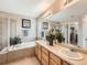 Large bathroom with double sinks, shower, soaking tub, and walk-in closet at 8522 S Dudley St, Littleton, CO 80128