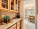 Elegant butler's pantry with granite countertops, wine rack, and glass-front cabinets, open to dining area at 8522 S Dudley St, Littleton, CO 80128