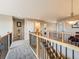 Upstairs hallway with wood and wrought iron banister, and neutral carpet at 8522 S Dudley St, Littleton, CO 80128