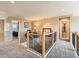 Hallway with railing, offering views into other rooms and natural light at 8522 S Dudley St, Littleton, CO 80128