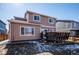 Back exterior featuring sliding glass doors to deck and spacious fenced yard, perfect for enjoying the outdoors at 1099 Thornbury Pl, Highlands Ranch, CO 80129