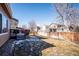 Spacious backyard with a wooden deck and partial snow cover, perfect for outdoor entertaining at 1099 Thornbury Pl, Highlands Ranch, CO 80129