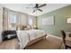Inviting bedroom features modern decor, a ceiling fan, and natural light filtering through the large windows at 1099 Thornbury Pl, Highlands Ranch, CO 80129