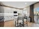 Modern kitchen with white cabinets, stainless steel appliances, a large island, and stylish barstool seating at 1099 Thornbury Pl, Highlands Ranch, CO 80129