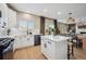 Well-lit kitchen featuring modern white cabinets, stainless steel appliances, and a breakfast bar with easy access to dining at 1099 Thornbury Pl, Highlands Ranch, CO 80129