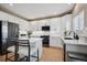 Bright and modern kitchen featuring white cabinetry, stainless steel appliances, and a functional center island with seating at 1099 Thornbury Pl, Highlands Ranch, CO 80129