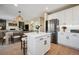 Open concept kitchen with stainless steel appliances, a central island, and seamless transition to the dining area at 1099 Thornbury Pl, Highlands Ranch, CO 80129