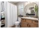 Cozy bathroom featuring a shower with curtain, a vanity with cabinet storage, and a round mirror at 4873 S Fultondale Way, Aurora, CO 80016