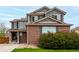 Inviting two-story home featuring brick accents, gray siding, and well-maintained landscaping at 4873 S Fultondale Way, Aurora, CO 80016