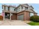 Attractive home featuring brick, gray siding, a two-car garage, and well-maintained landscaping at 4873 S Fultondale Way, Aurora, CO 80016