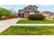 Charming two-story home with a well-manicured lawn, mature trees, and brick and siding exterior at 4873 S Fultondale Way, Aurora, CO 80016