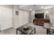 Open basement living space with seating, a TV, and neutral walls at 4873 S Fultondale Way, Aurora, CO 80016