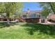 Backyard featuring a deck and a large, green lawn at 1105 Oakhurst Dr, Broomfield, CO 80020