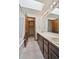 Bright bathroom with a double sink vanity, large mirror, a tub and shower with a skylight at 1105 Oakhurst Dr, Broomfield, CO 80020