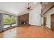 Elegant living room featuring a brick fireplace, hardwood floors, and large windows, creating a warm and inviting atmosphere at 1105 Oakhurst Dr, Broomfield, CO 80020