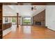Stunning living room boasts a brick fireplace, wood floors, and seamless access to the kitchen and outdoor views at 1105 Oakhurst Dr, Broomfield, CO 80020