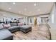 Open basement layout connecting the living area to the modern kitchen, perfect for entertaining at 25 N Irvington St, Aurora, CO 80018