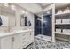 Beautiful bathroom featuring double vanity, gold fixtures, and blue tiled shower with glass door at 25 N Irvington St, Aurora, CO 80018