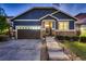 Attractive home showcasing stone veneer, blue siding, well-lit walkway, and a two-car garage at 25 N Irvington St, Aurora, CO 80018