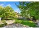 Landscaped backyard featuring mature trees, stone pathways, and a well-maintained lawn for outdoor enjoyment at 2251 Cliffrose Ln, Louisville, CO 80027