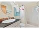 Well-lit bathroom with a tiled backsplash, modern vanity, and shower with a curtain at 2251 Cliffrose Ln, Louisville, CO 80027