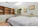 A cozy bedroom with light green walls, wooden shelves, and a window at 2251 Cliffrose Ln, Louisville, CO 80027
