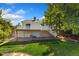 Rear exterior view of a home featuring a deck, a well-maintained lawn, and mature trees at 2251 Cliffrose Ln, Louisville, CO 80027