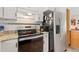 Modern kitchen with updated appliances, tile backsplash, and granite countertops at 2251 Cliffrose Ln, Louisville, CO 80027