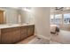 Bathroom featuring double sinks, wood-look tile floor, and a large mirror at 2144 Coyote Mint Dr, Monument, CO 80132