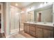 Bathroom featuring glass shower, double sinks, and modern fixtures at 2144 Coyote Mint Dr, Monument, CO 80132