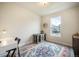 Bedroom with natural light, blue patterned rug, small pet carrier and neutral colored walls at 2144 Coyote Mint Dr, Monument, CO 80132