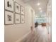 Hallway with wood floors, framed photos, and a view to the living area with natural light at 2144 Coyote Mint Dr, Monument, CO 80132