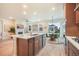 Bright open kitchen featuring an island with seating and a view to the Gathering room with fireplace at 2144 Coyote Mint Dr, Monument, CO 80132
