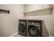 Modern laundry room with a washer, dryer, and overhead shelf at 2144 Coyote Mint Dr, Monument, CO 80132