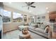 Bright and airy living room area featuring large windows, a ceiling fan, and an open layout design at 2144 Coyote Mint Dr, Monument, CO 80132