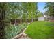 Scenic backyard with lush landscaping, mature trees, and a storage shed, providing a peaceful outdoor retreat at 4982 S Danube St, Aurora, CO 80015