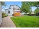 Spacious backyard with lush green grass, a wood deck, and a charming pergola, perfect for outdoor living at 4982 S Danube St, Aurora, CO 80015