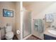 Bathroom featuring a vanity with sink, toilet, framed art, and glass shower with updated fixtures at 4982 S Danube St, Aurora, CO 80015