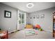 Bright room with neutral walls, carpet, window, overhead fan, and decor for children to enjoy at 4982 S Danube St, Aurora, CO 80015