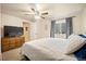 Bright bedroom with carpet, a ceiling fan, dresser and TV at 4982 S Danube St, Aurora, CO 80015