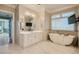Bright bathroom features a soaking tub, tiled floors, vanity with drawers, and a large mirror with a tv at 1757 Whistlepig Ln, Broomfield, CO 80020