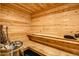 Wood paneled sauna with tiered bench seating and traditional heater with sauna stones at 1757 Whistlepig Ln, Broomfield, CO 80020