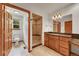 Bright bathroom featuring tile flooring, wooden vanity, and a tiled walk-in shower with built-in bench at 379 Lincoln Ct, Louisville, CO 80027