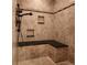 Elegant bathroom featuring a tiled shower with a built-in bench and recessed shelving at 379 Lincoln Ct, Louisville, CO 80027