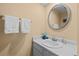 Clean half bathroom featuring a round mirror, white vanity, and fresh towels at 2090 S Gray Dr, Lakewood, CO 80227
