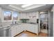 Well-lit kitchen offers white cabinetry, granite counters, and access to dining area at 2090 S Gray Dr, Lakewood, CO 80227