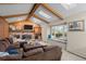Cozy living room featuring exposed beams, skylights, and a brick fireplace with a large sectional couch at 2090 S Gray Dr, Lakewood, CO 80227