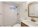 Modern bathroom featuring white subway tile, light wood vanity, and stylish fixtures at 14317 Olmsted Dr, Denver, CO 80239