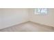 Empty room features a neutral carpet, white walls, and a large window at 14317 Olmsted Dr, Denver, CO 80239